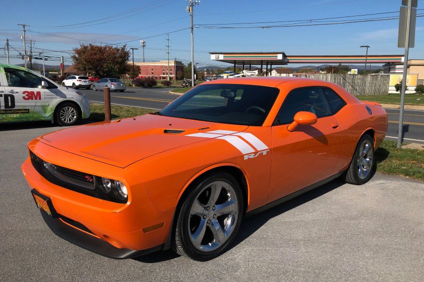 Orange Dodge Challenger with tinted windows